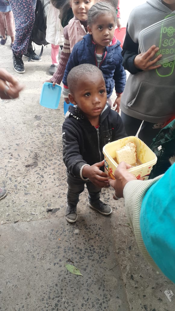 Child receiving a hot meal in Ocean View